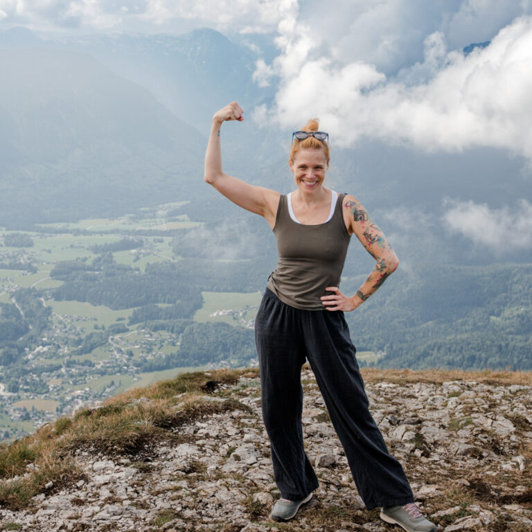 Miriam Mehlman mit erhobenem Arm am Loser vor Berglandschaft und Wolken beim Urlaub in Bad Aussee.