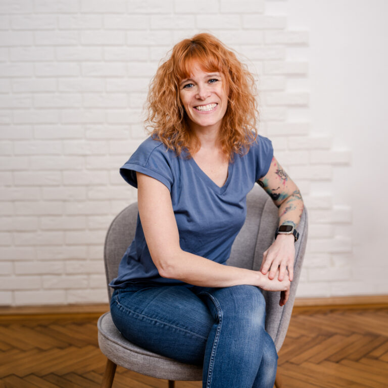 Fotografin Miriam Mehlman sitzt entspannt auf einem Sessel Portrait mit viel Freiraum für Text-Overlays.