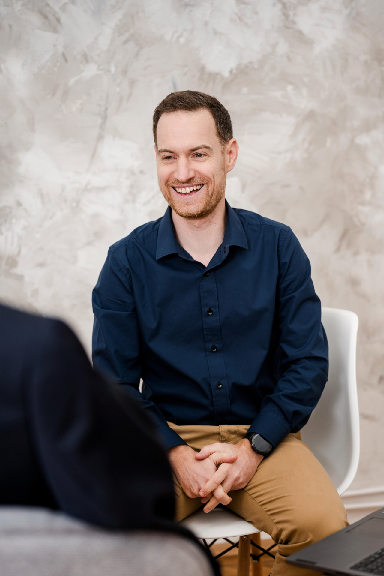 Personal Branding Fotografie Wien: Markus Schick Consulting im Gespräch, den Laptop auf dem Schoß, während er eine Strategie erklärt.