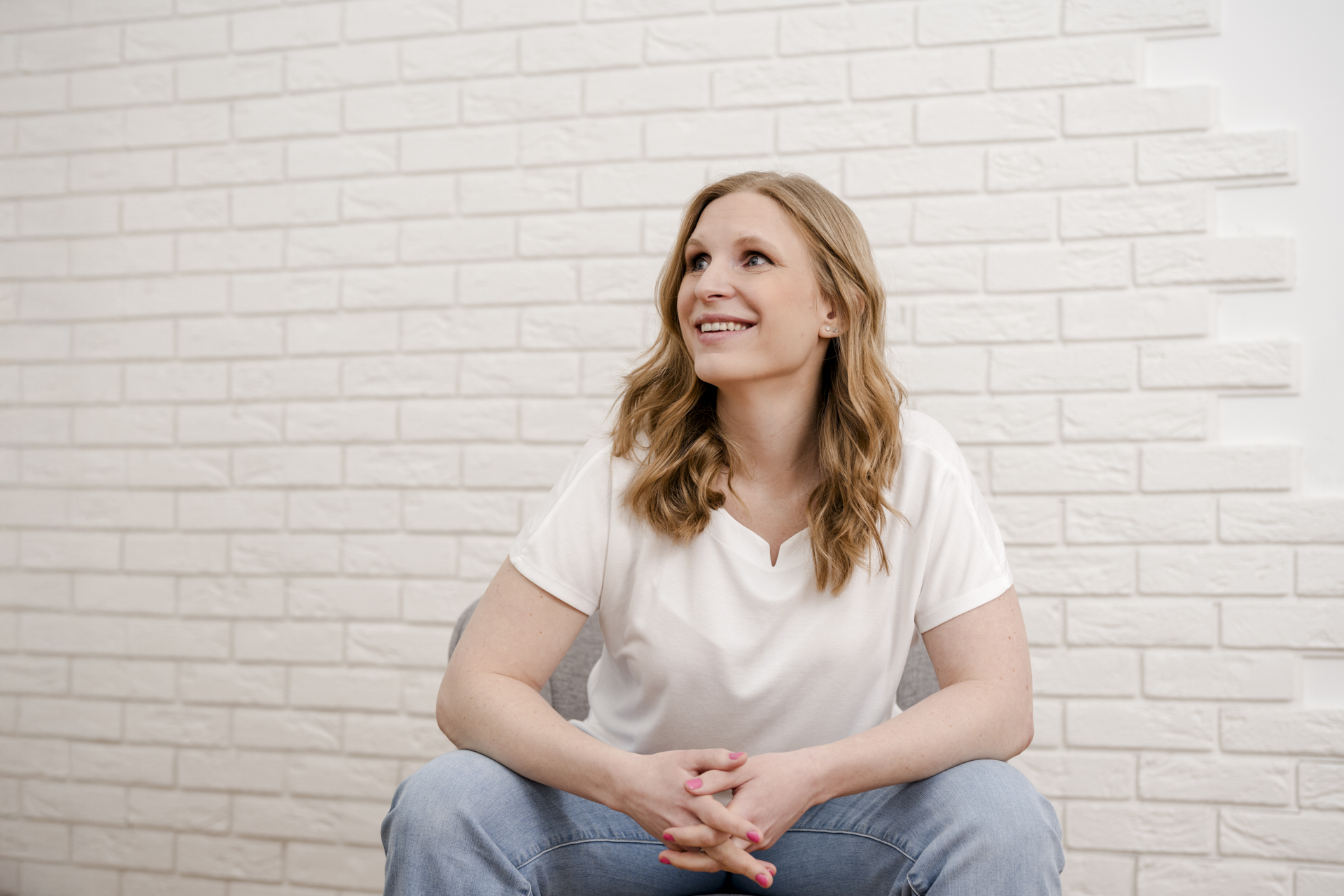 Kathrin Zhuber von DOC-N-ROLL sitzt während eines Personal Branding Shootings auf einem Sessel und blickt zur Seite.
