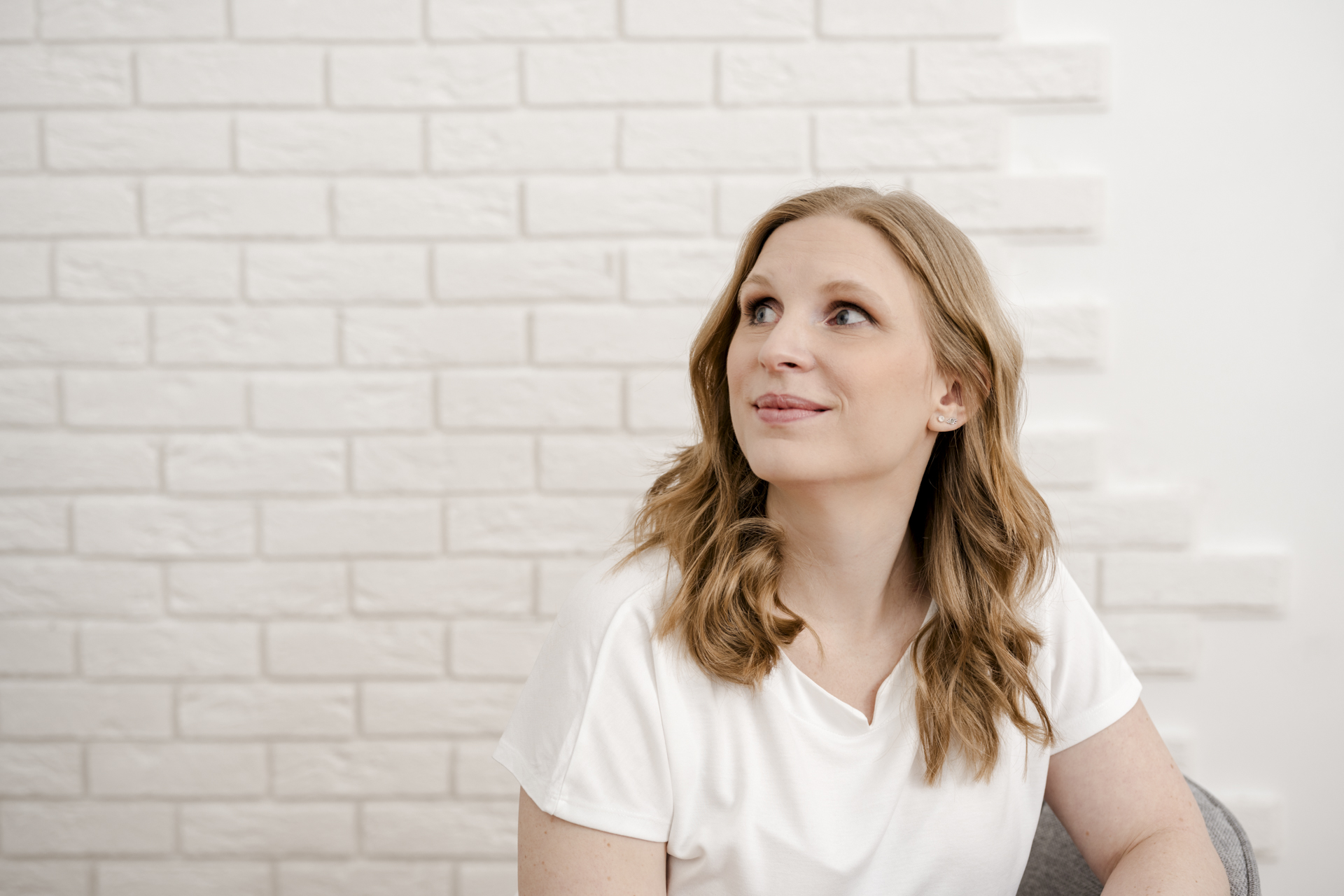 Kathrin Zhuber von DOC-N-ROLL während eines Personal Branding Shootings vor einer weißen Ziegelwand.
